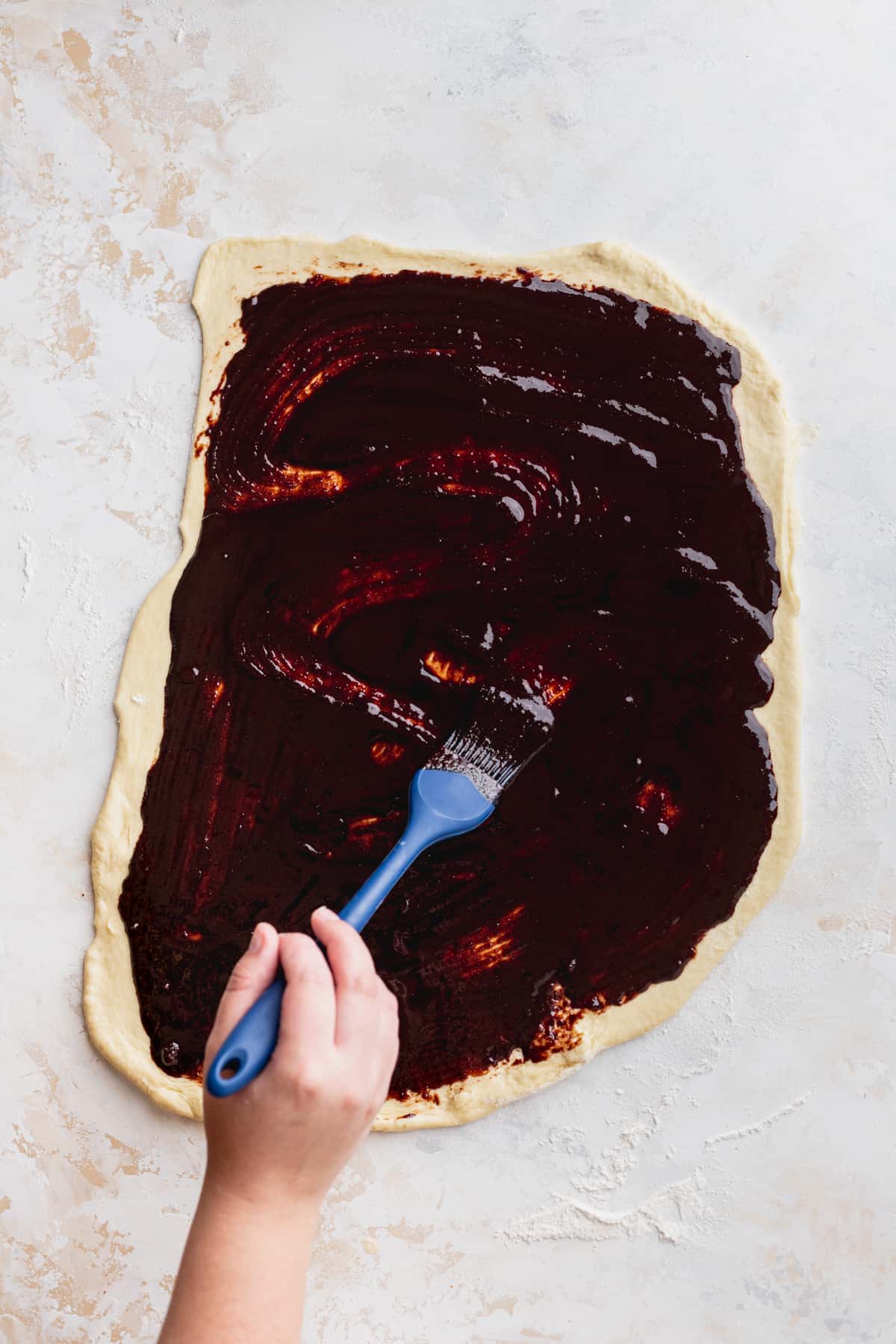 Spreading chocolate filling on the dough.