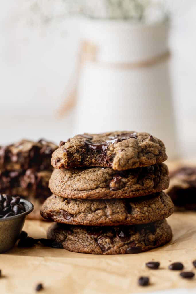 Stack of espresso chocolate chip cookies with a bite missing.