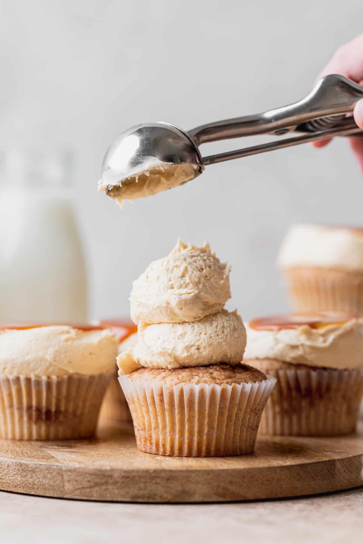 Topping cupcakes with caramel frosting.