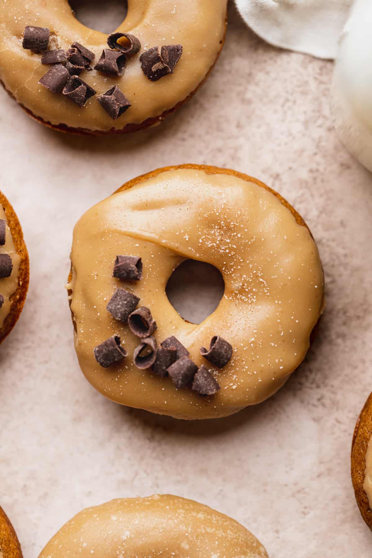 Pumpkin donuts with maple glaze with chocolate curls on top.