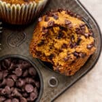 Bite missing from pumpkin chocolate chip muffins.