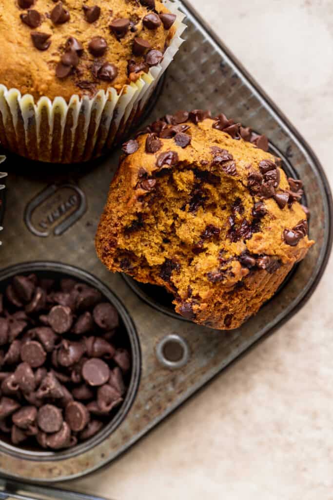 Bite missing from pumpkin chocolate chip muffins.