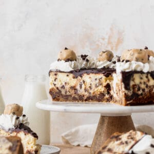 Chocolate chip cookie dough cheesecake on a cake stand.