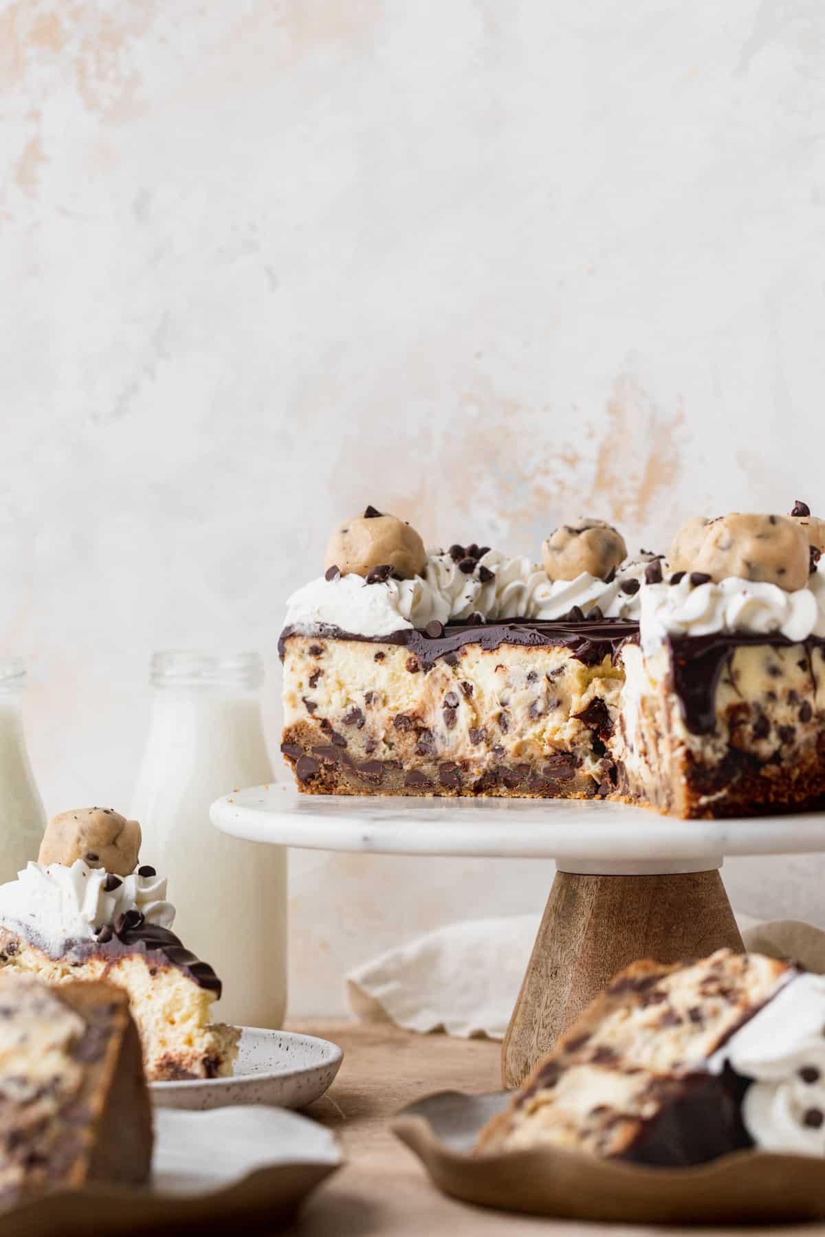 Chocolate chip cookie dough cheesecake on a cake stand.