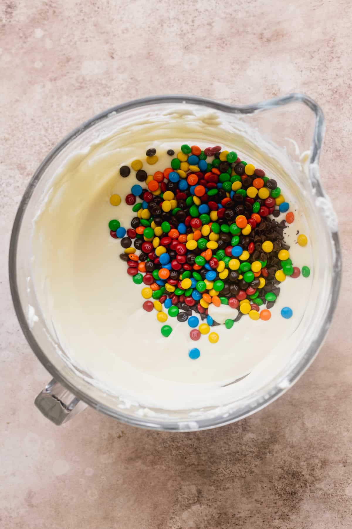 M&Ms on top of cheesecake batter.