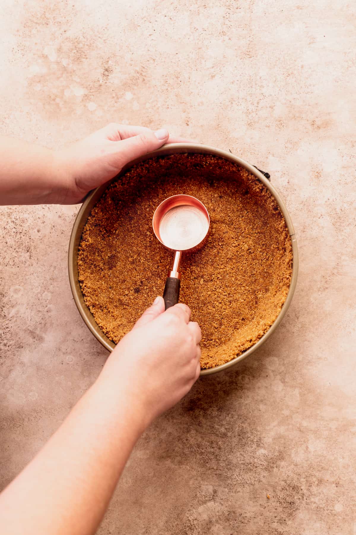 Pressing down the crust in a springform pan.