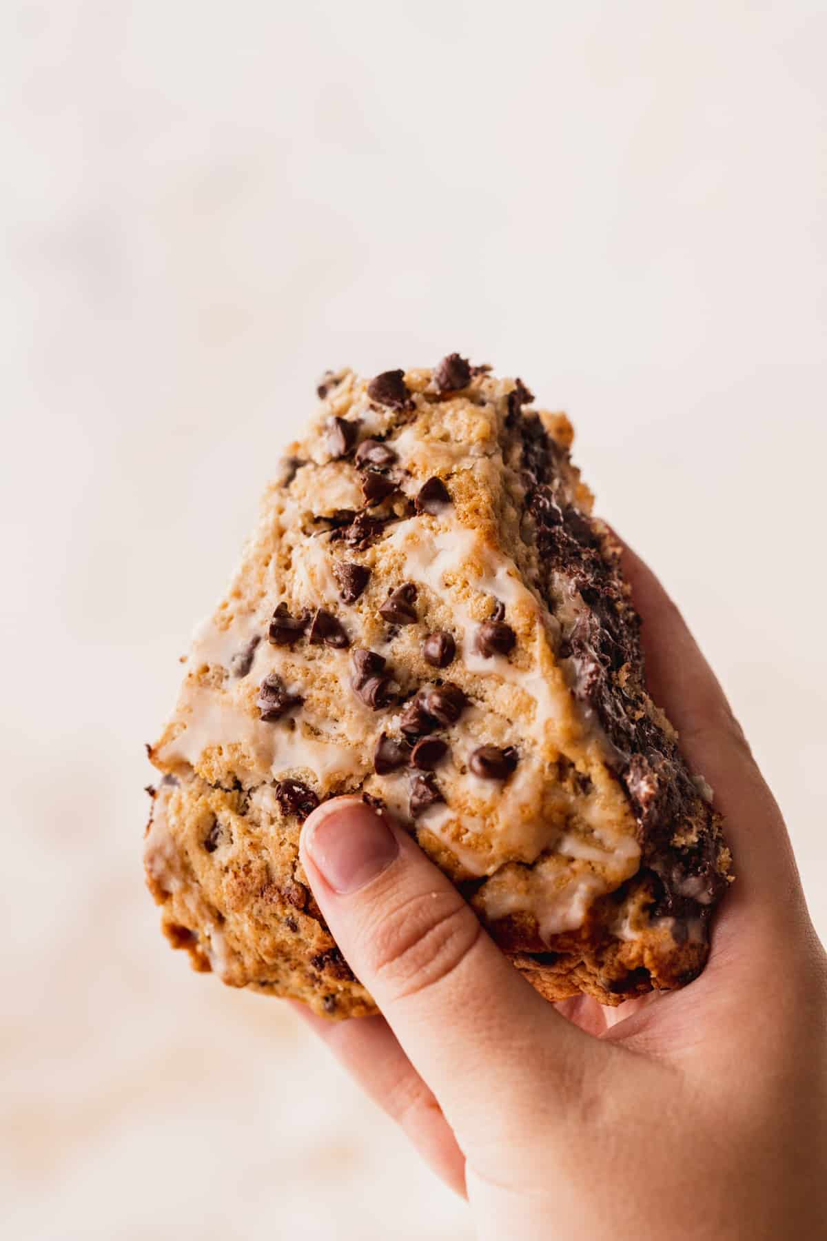 Holding up a chocolate chip stuffed scones.