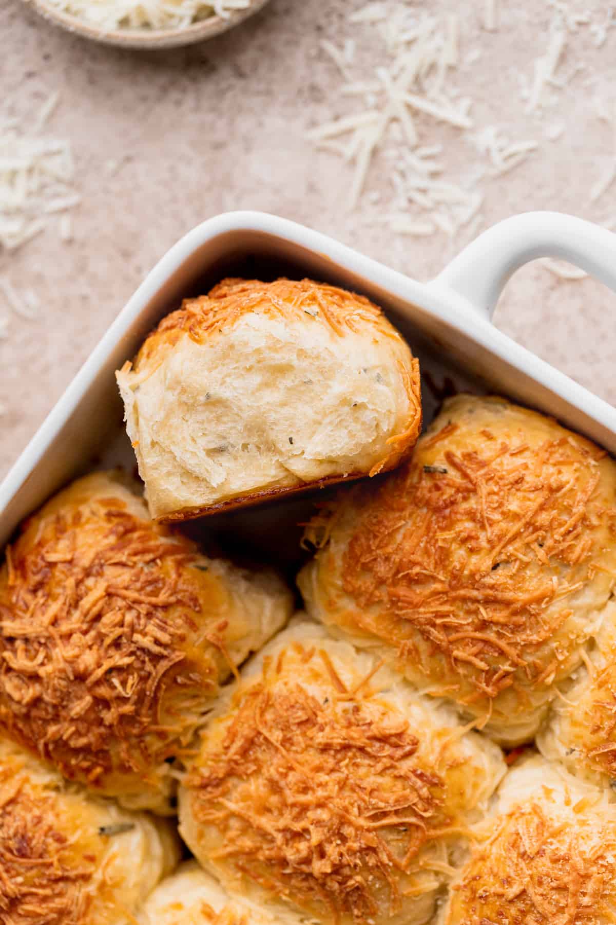 Fluffy cheddar cheese rolls with one on its side.