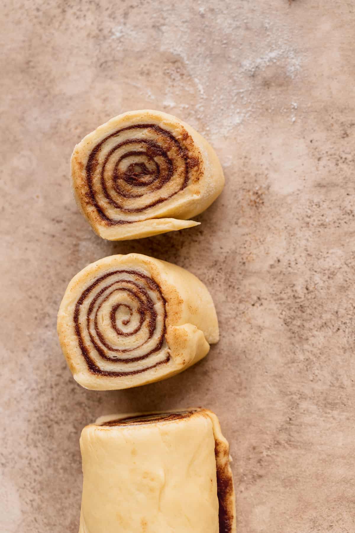 Cut cinnamon roll dough.
