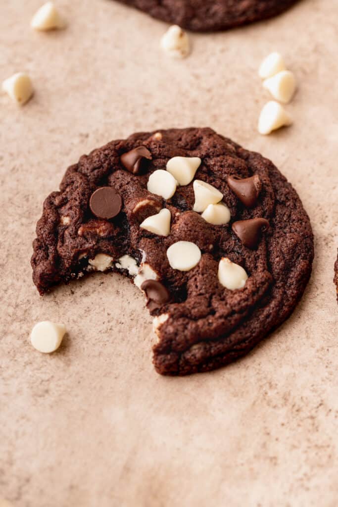 A bite missing from white chip double chocolate cookies.