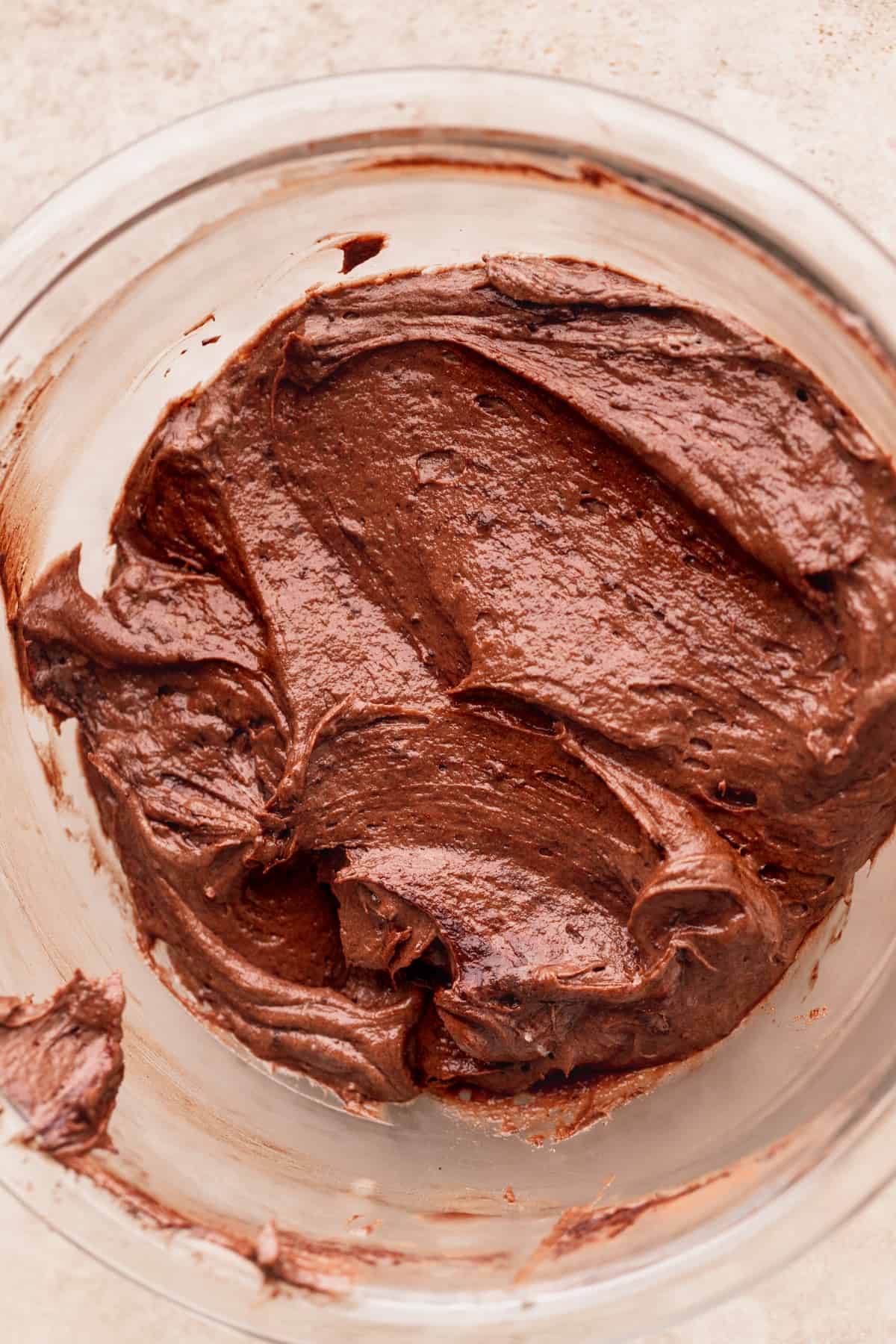 Chocolate cake batter in a glass bowl.