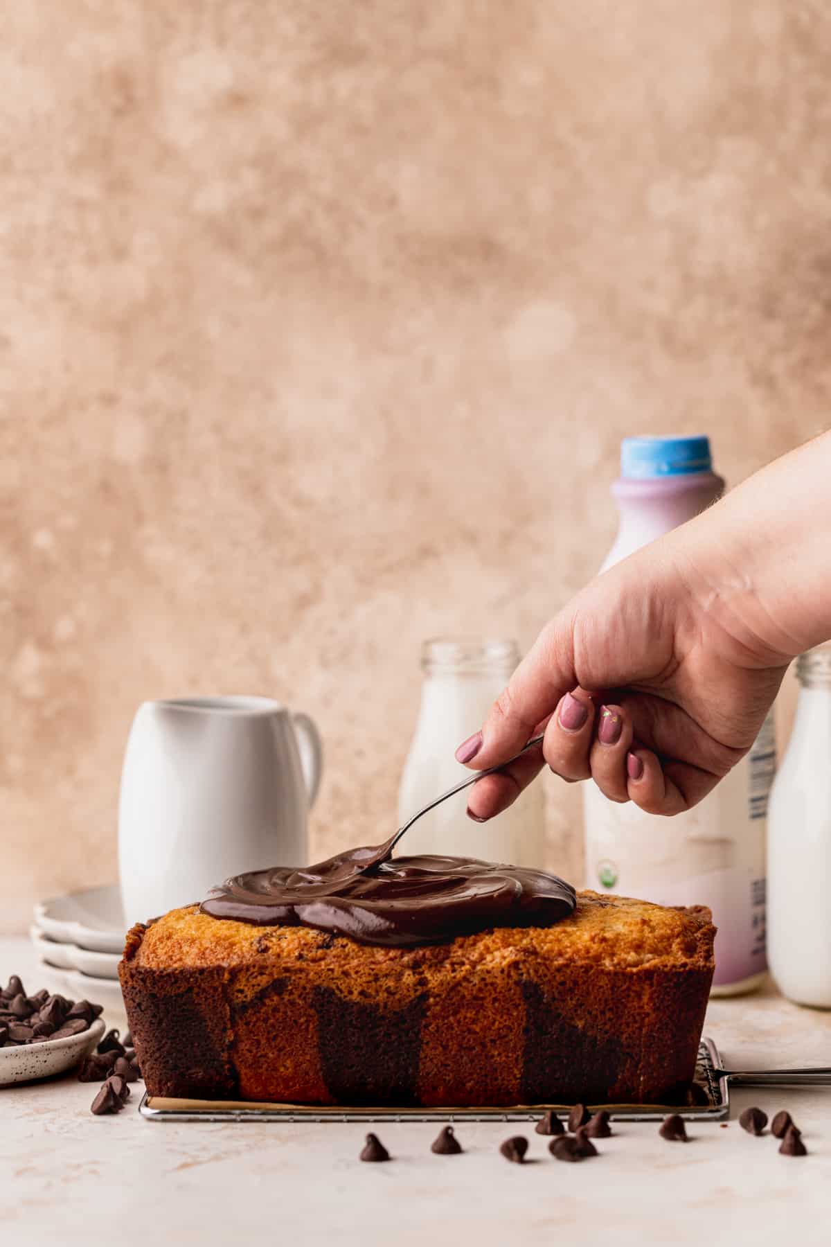 Spreading chocolate frosting on top of cake.