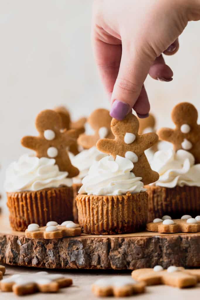 Placing a gingerbread man on top of whipped cream.