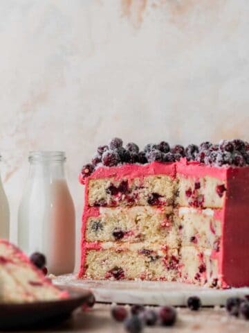 Three layers of Christmas cranberry cake on a board.