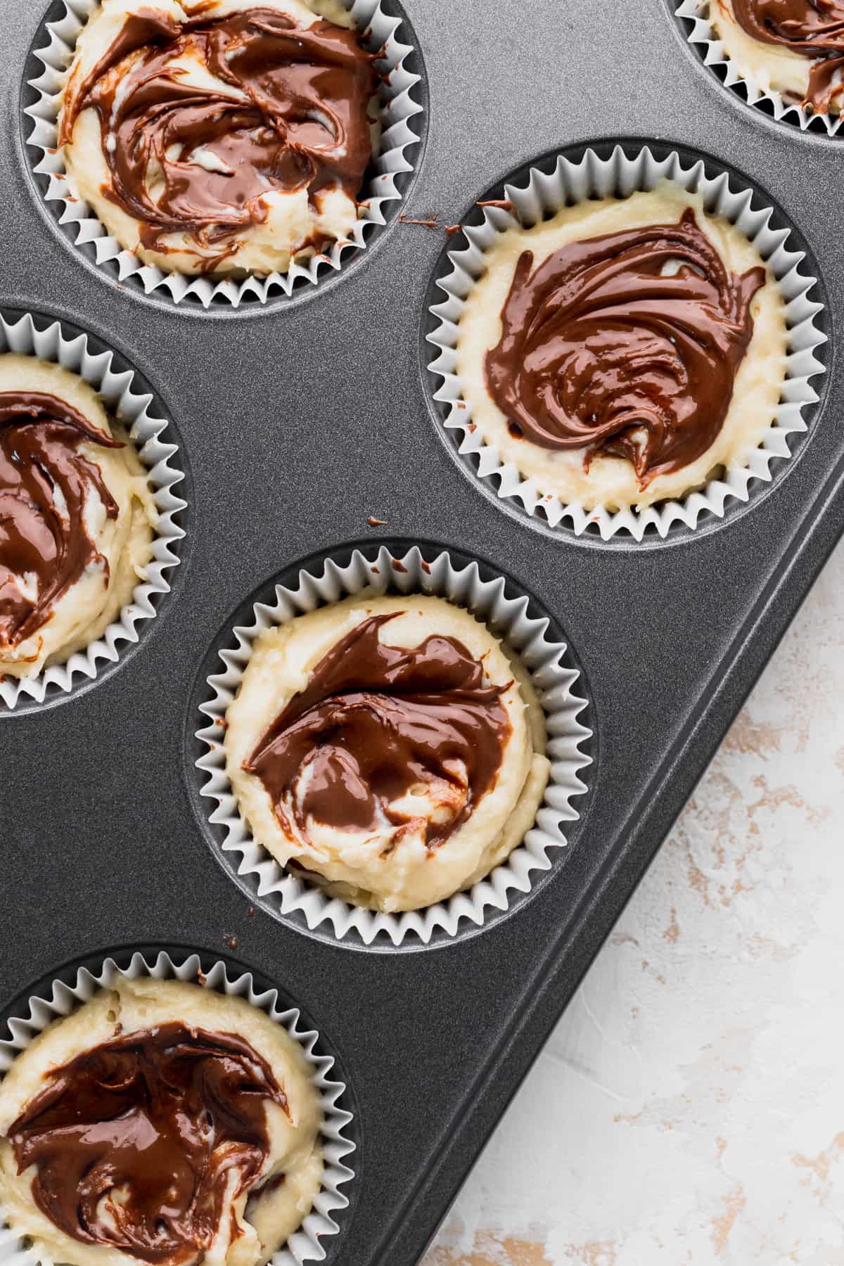 Nutella swirled on top of cupcake batter.