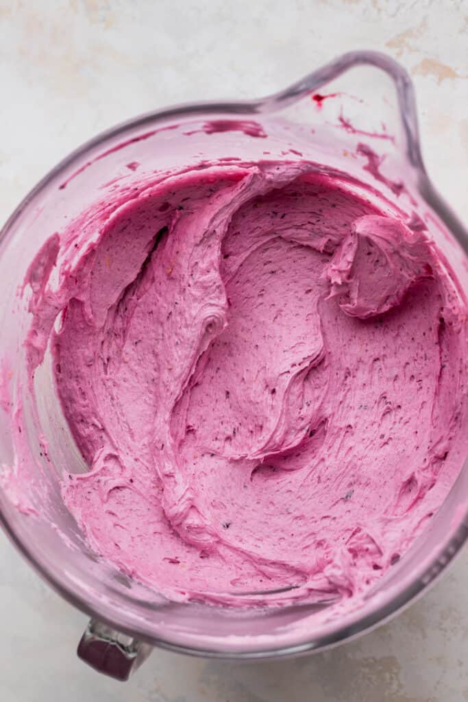 Blueberry frosting in a glass bowl.