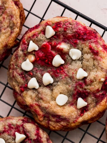 Raspberry white chocolate cookies on a wire rack.