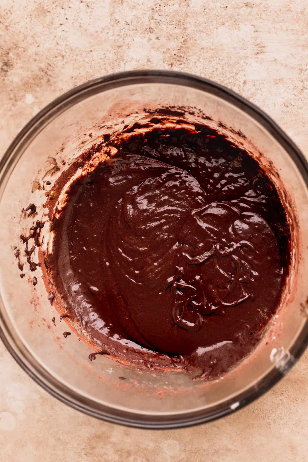 Brownie batter with dry ingredients added in a glass bowl.