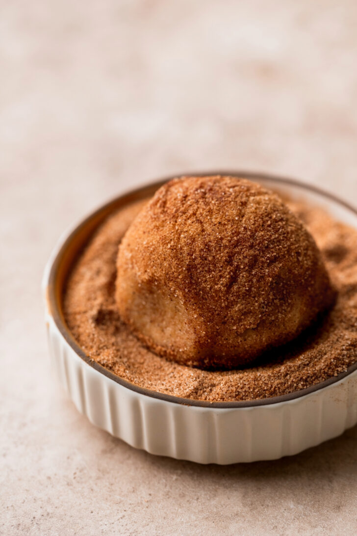 Cookie dough ball in cinnamon sugar.