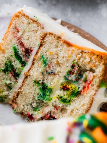 One cake slice of rainbow swirl cake on a platter.