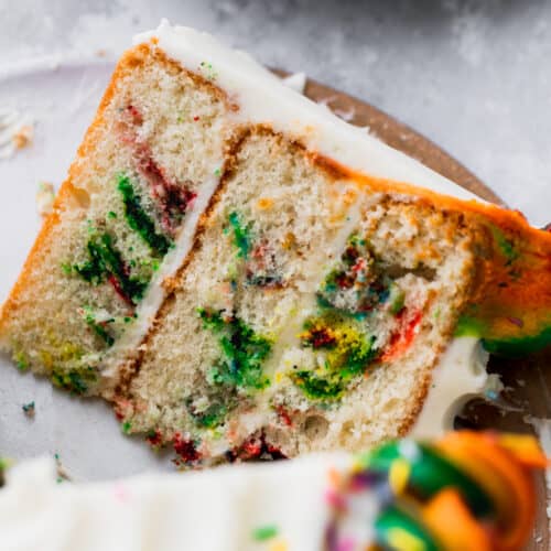 One cake slice of rainbow swirl cake on a platter.