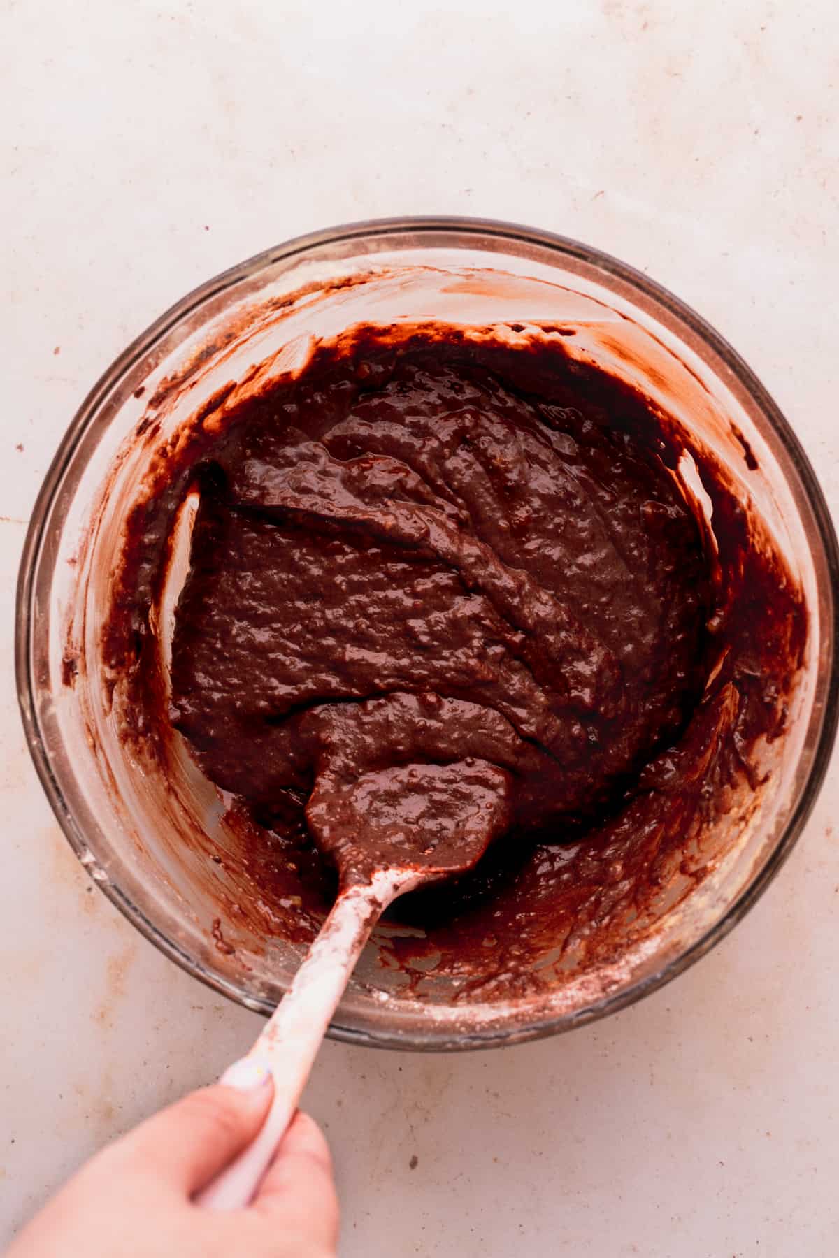 Chocolate banana bread batter in a glass bowl.