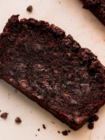 Once slice of double chocolate banana bread with chocolate chips around it.