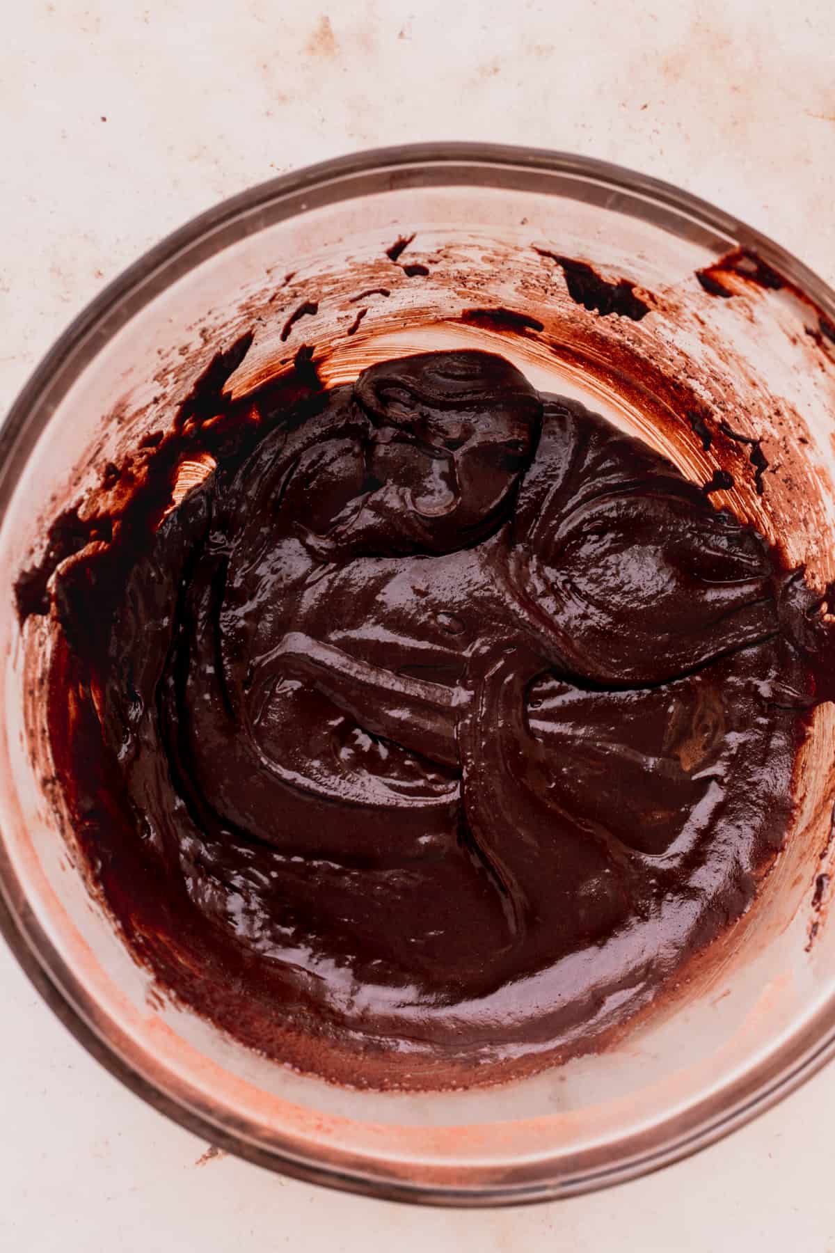 Chocolate brownie batter in a glass bowl.