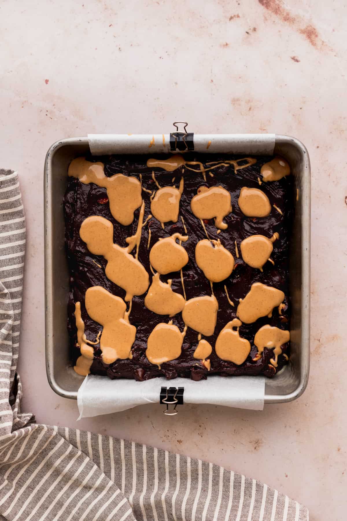 Peanut butter dollops on top of brownie batter.