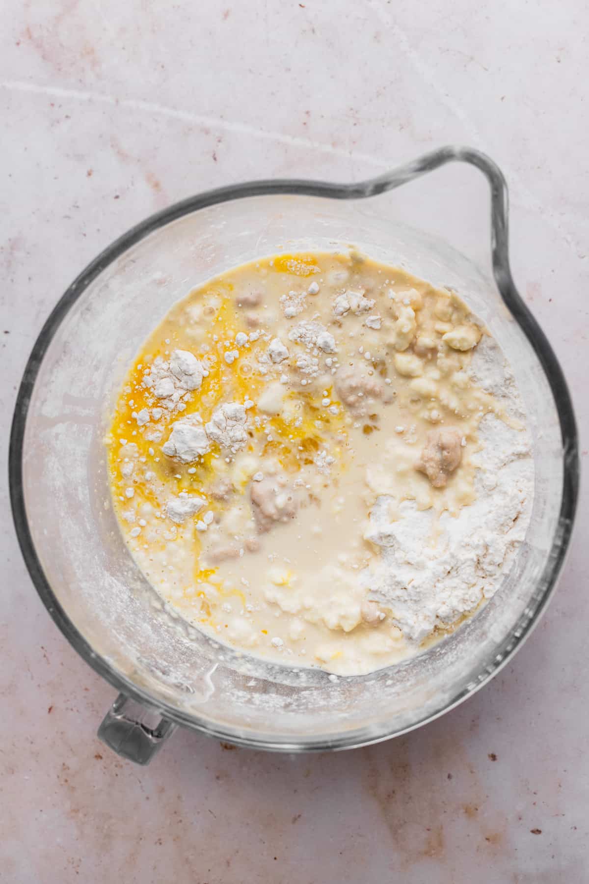 Wet ingredients on top of flour in a glass bowl.