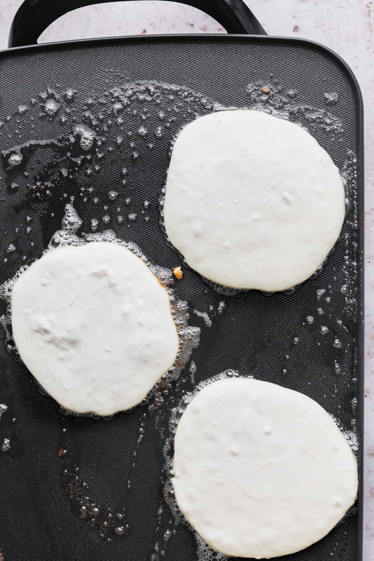 Pancake batter on top of hot griddle.