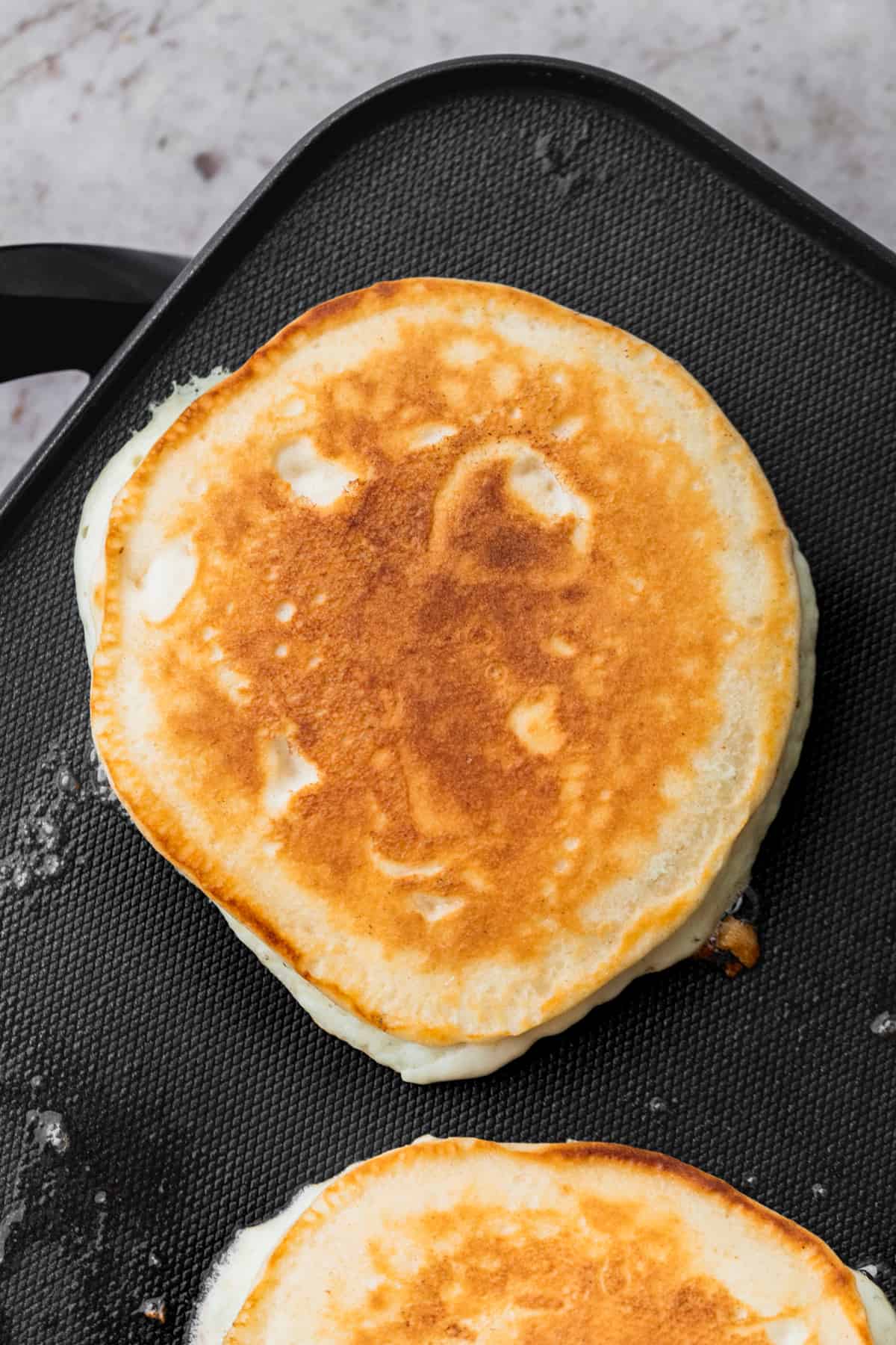 Cooked pancake on a hot griddle.