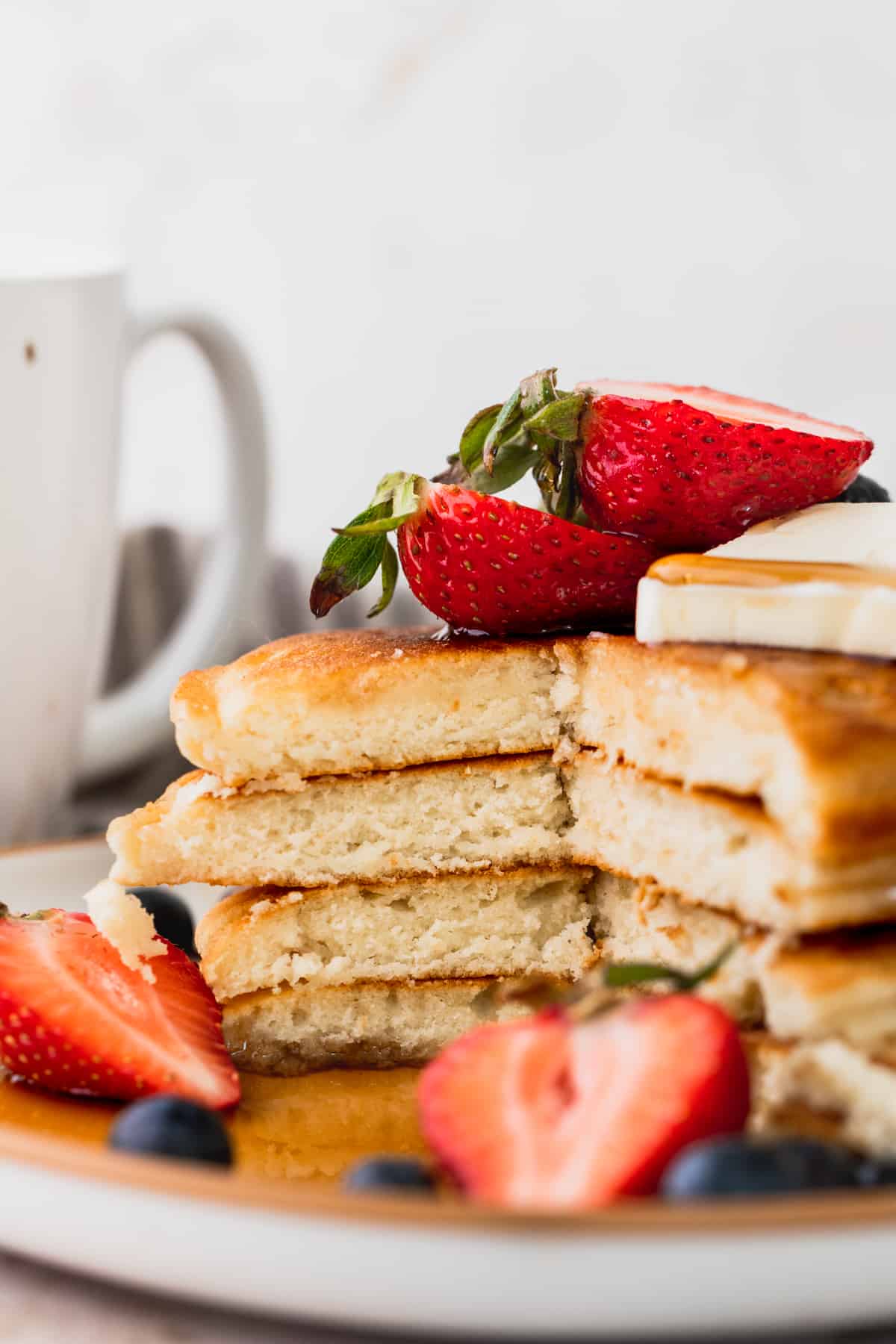 Stack of sweet cream pancakes cut into to show the insides.