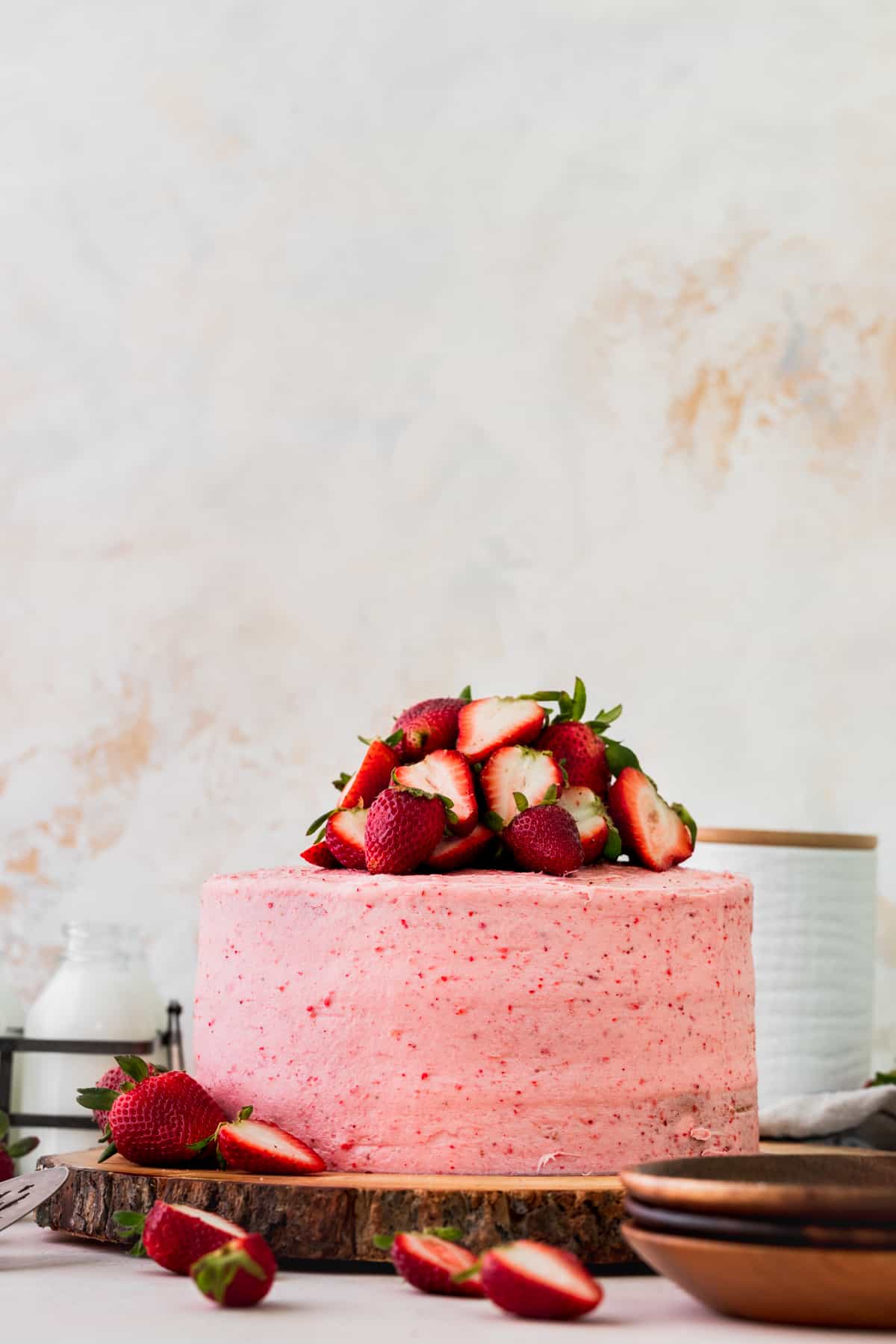Decorated strawberry vanilla cake on a wood board.