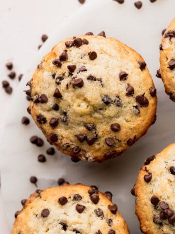 Top view of chocolate chip buttermilk muffins on a marble board.