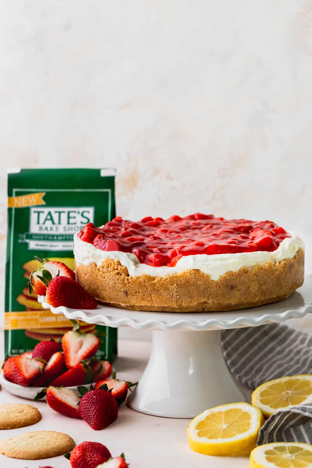 Lemon cheesecake with strawberry sauce on a cake stand.