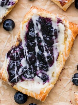 Close up of blueberry danish on parchment paper.