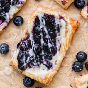 Close up of blueberry danish on parchment paper.