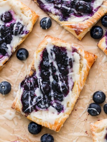 Close up of blueberry danish on parchment paper.