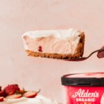 Taking one slice out of the strawberry ice cream cheesecake.