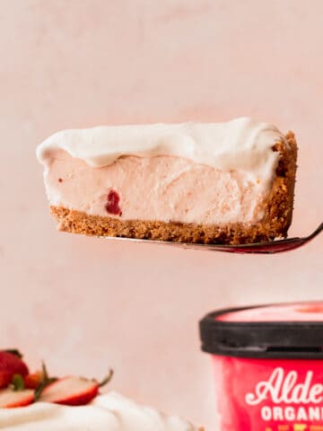 Taking one slice out of the strawberry ice cream cheesecake.