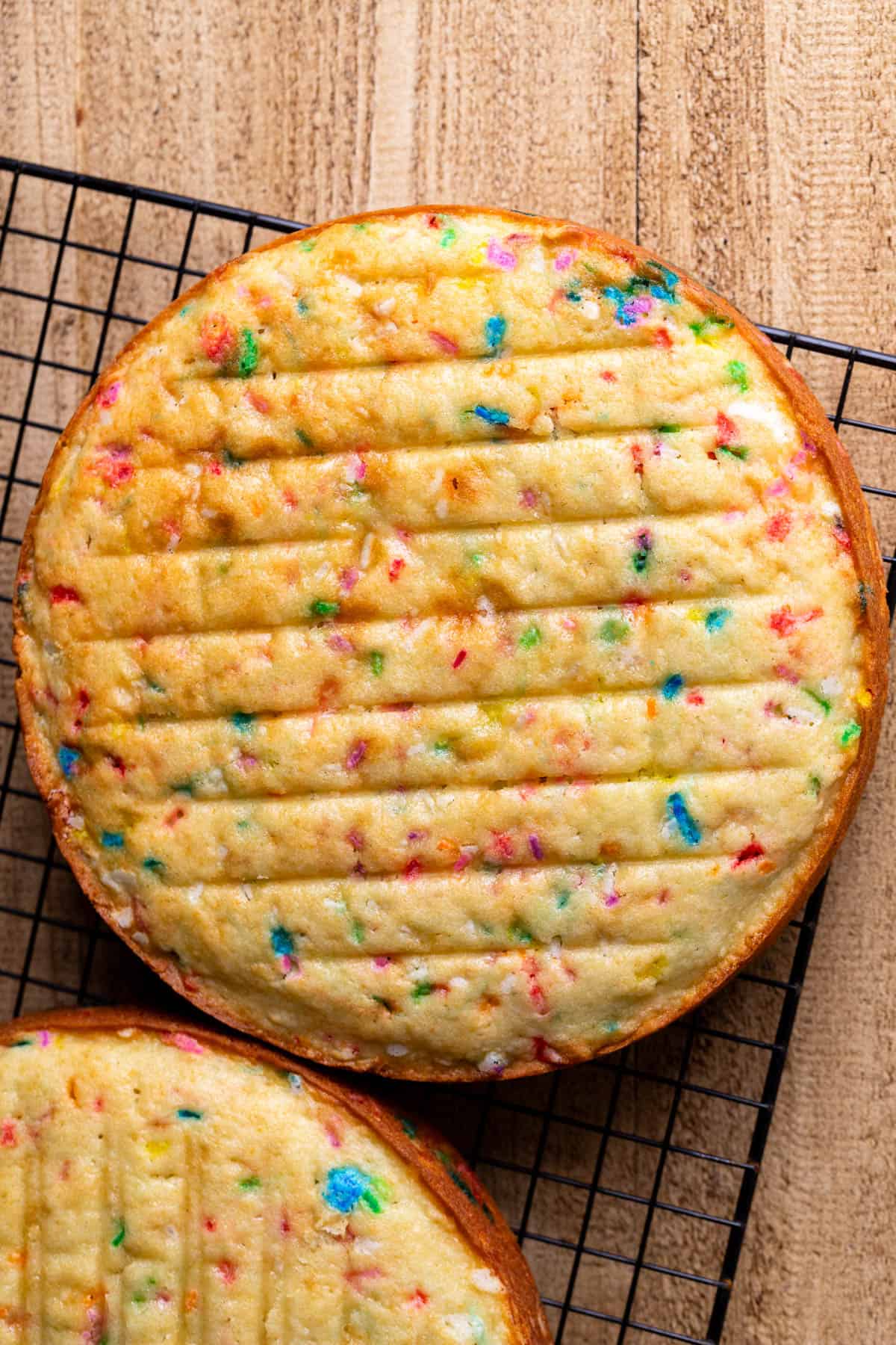 Funfetti cake layers on a wire rack.