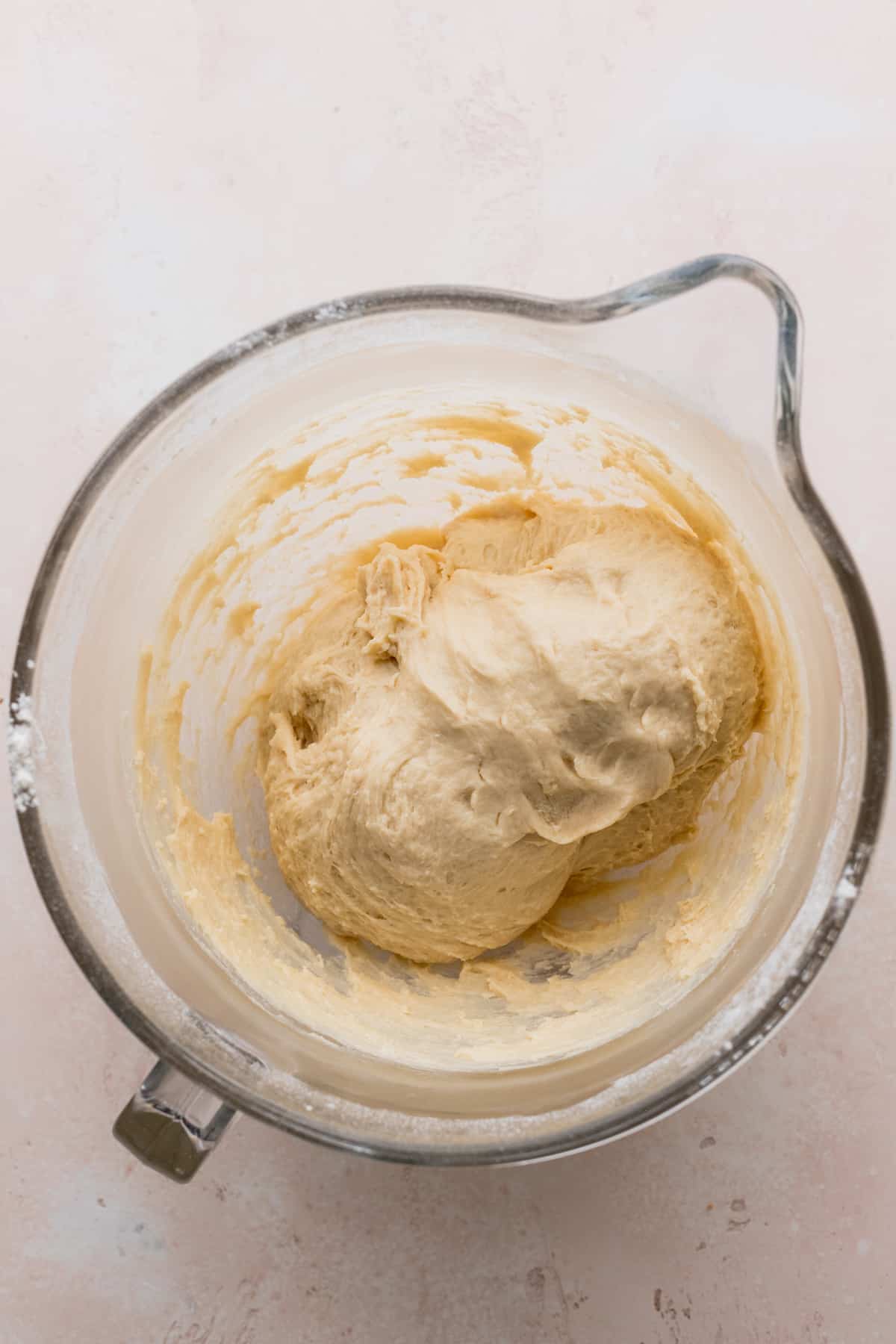 Kneaded dough in a large glass bowl.