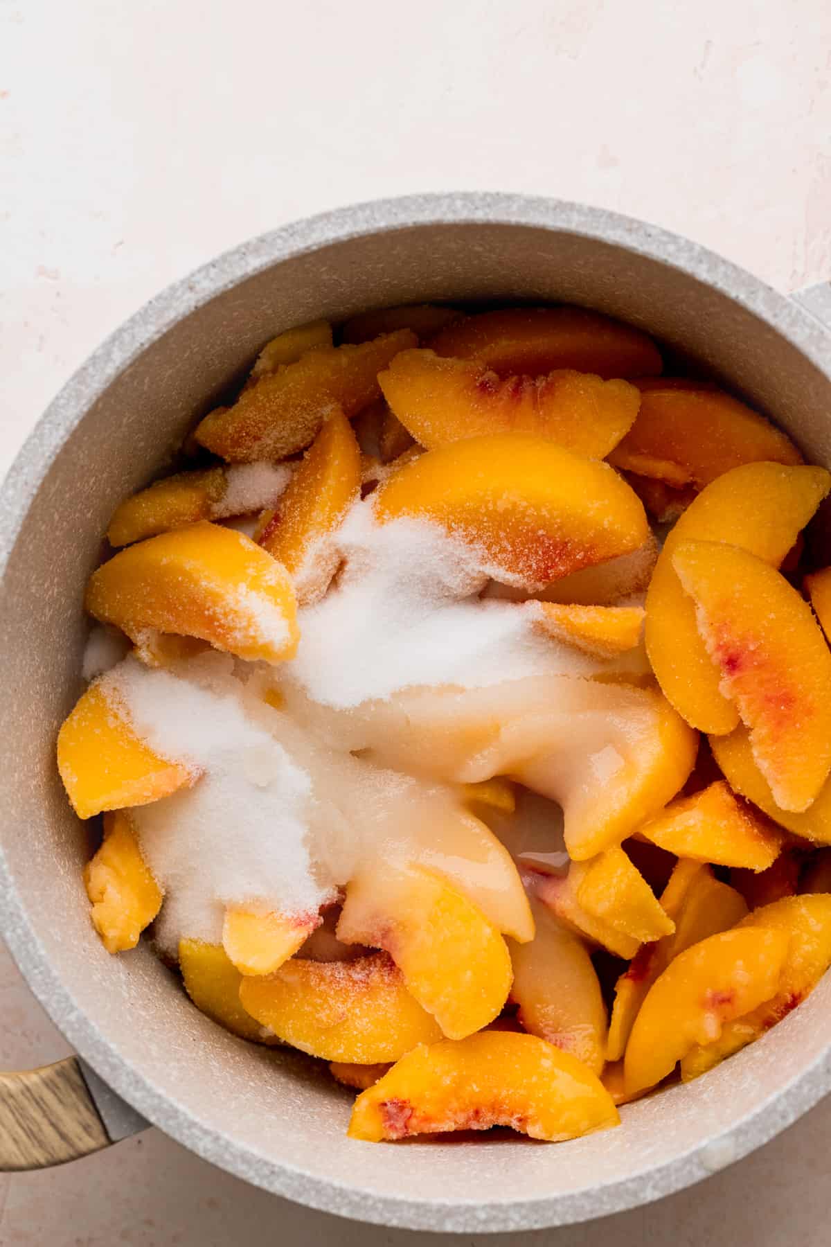 Peaches and sugar in a pot.