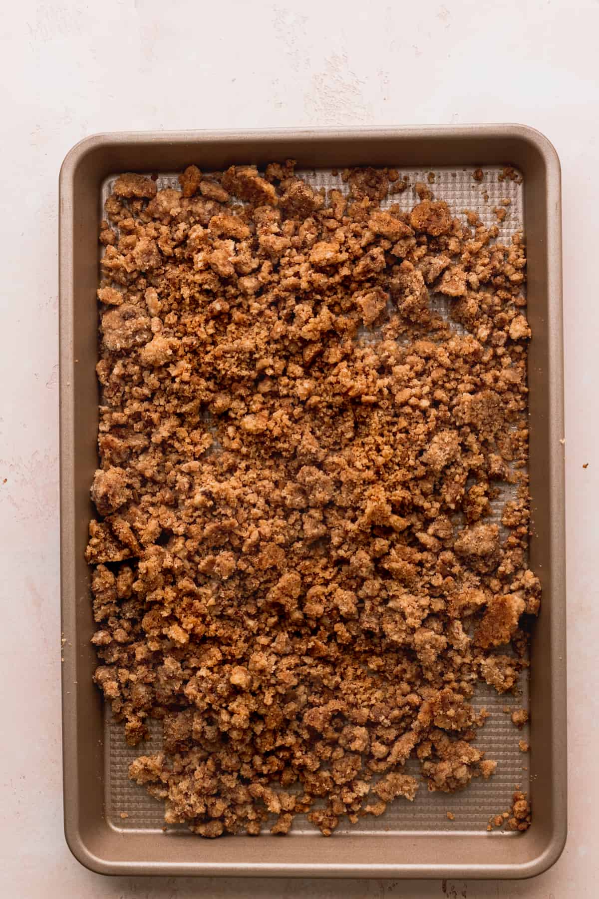 Cinnamon crumb topping on a baking sheet.