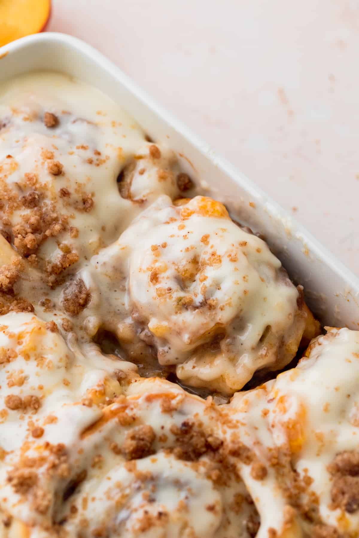 Peach cobbler cinnamon rolls in a baking pan.