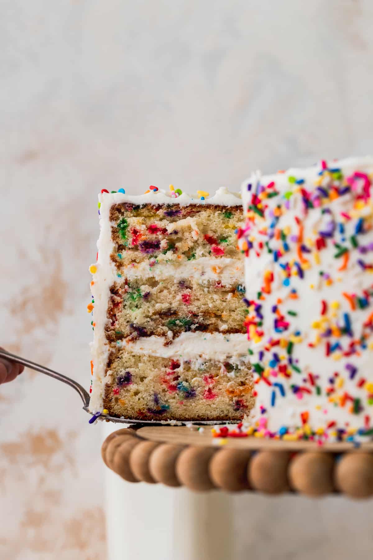 Taking one slice out of the funfetti cake.