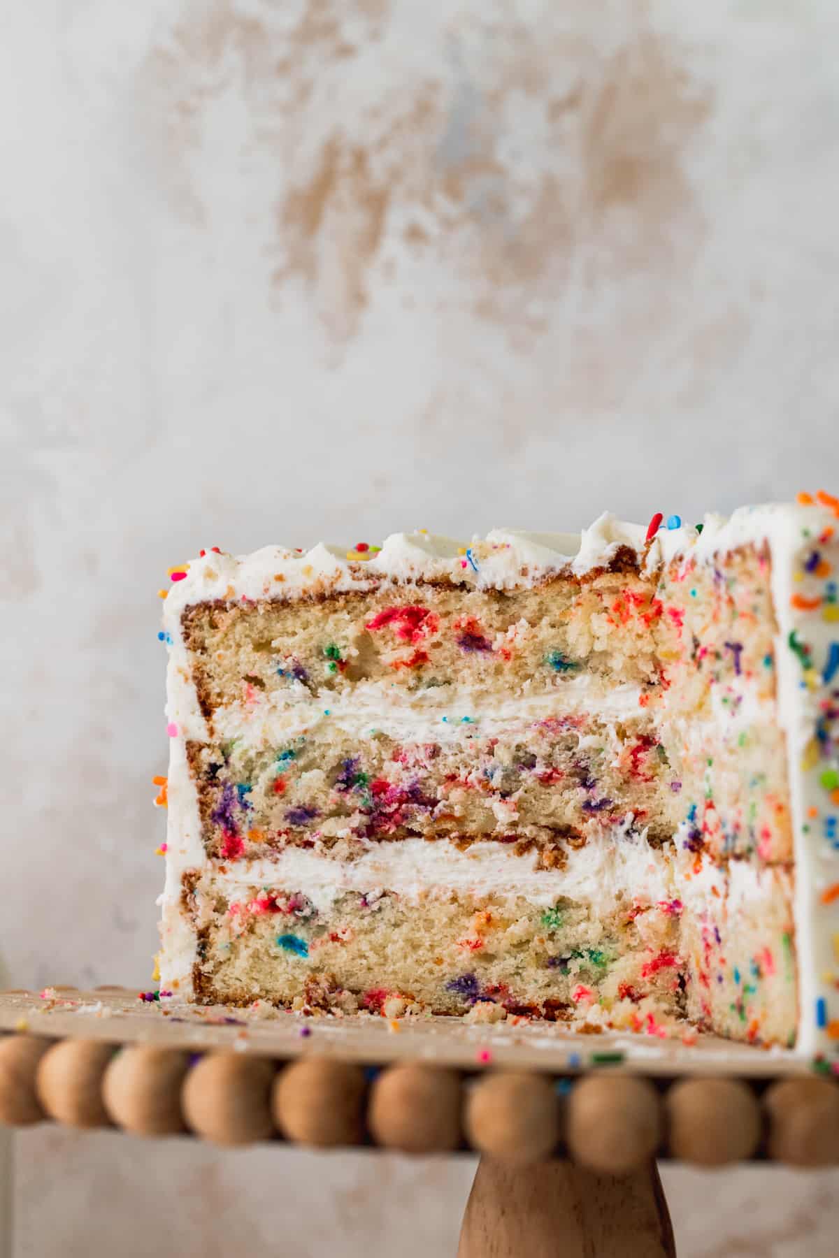 Cake split in half on a cake stand.
