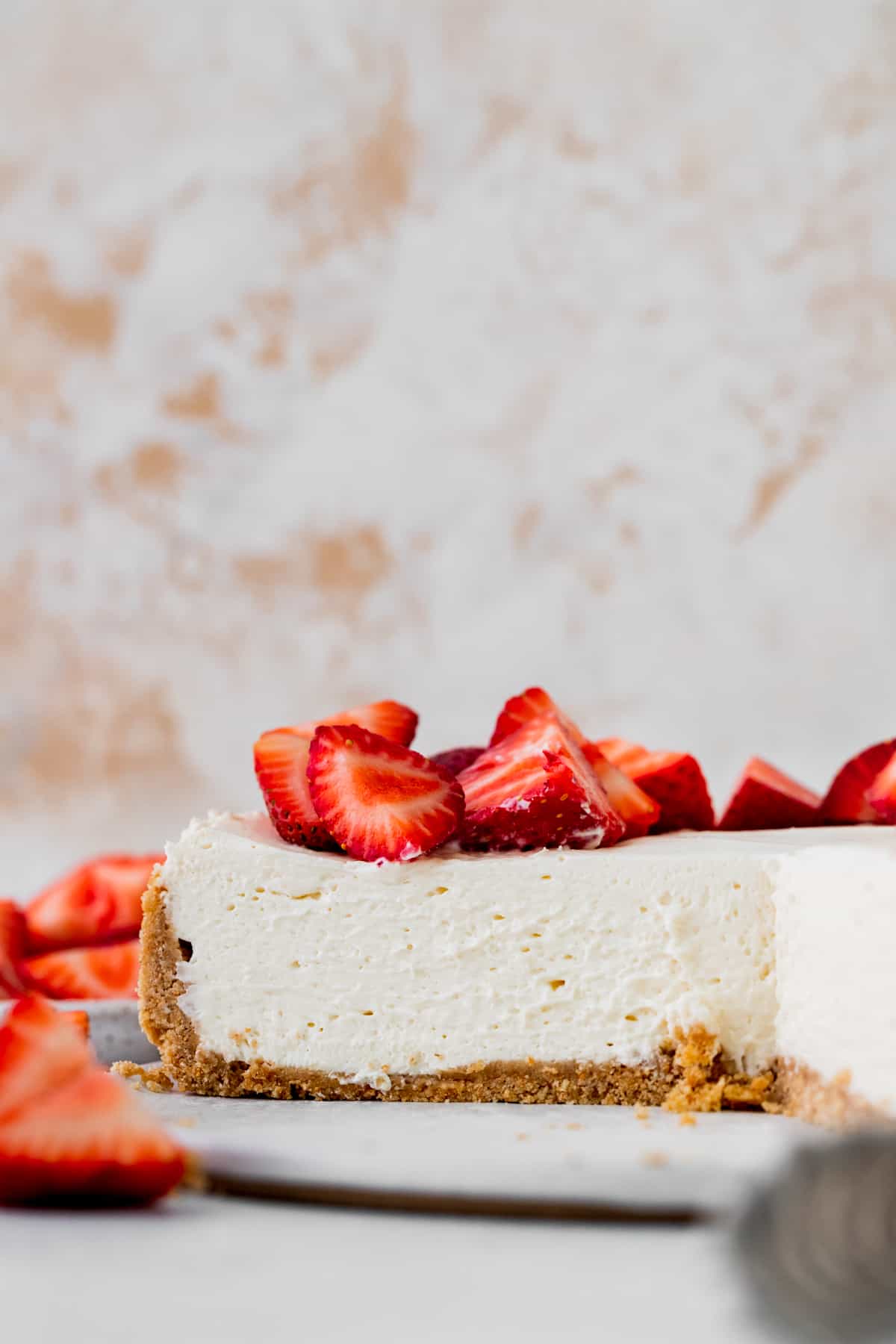 Side view of cheesecake on white board.