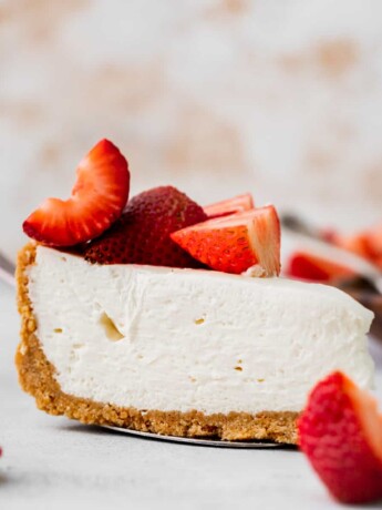 One slice of no bake vanilla cheesecake on a pie cutter.